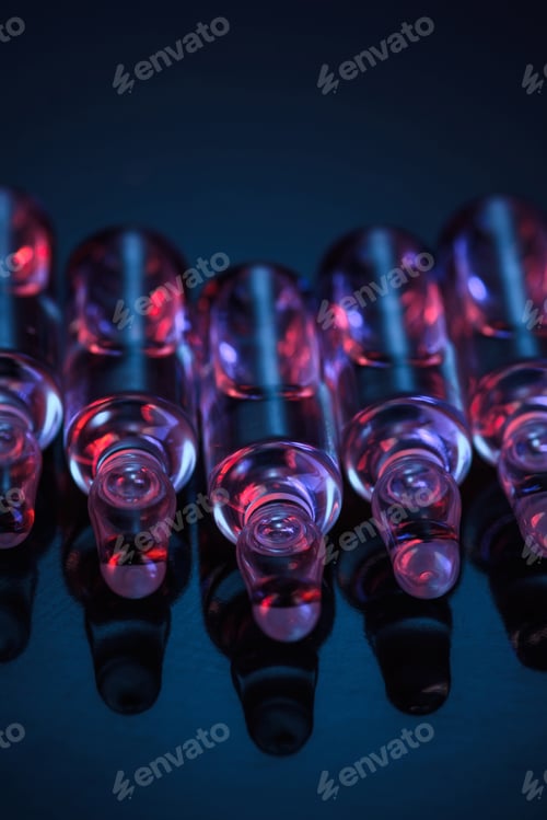 Preview: close up of transparent glass ampoules with liquid on table