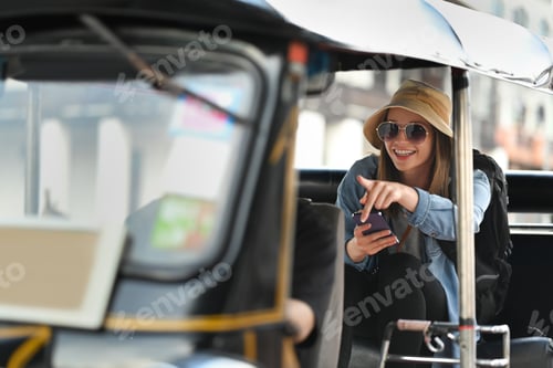 Preview: Exited caucasian woman tourist with sunglasses sitting in back seat of Tuk Tuk public transport
