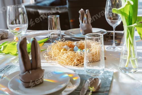 Preview: Beautiful Easter table setting with festive decor indoors. Napkin in shape of rabbit ears,