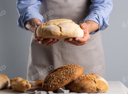 Preview: Baker holding freshly baked bread over table