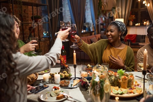 Preview: Friends toasting with red wine at the table