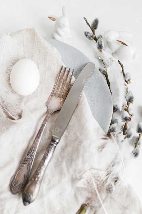 Preview: Stylish Easter table setting flat lay. Natural easter egg, pussy willow branches, feathers