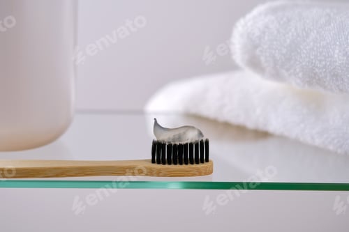Preview: Toothbrush, toothpaste and bath accessories on a glass shelf in the bathroom.