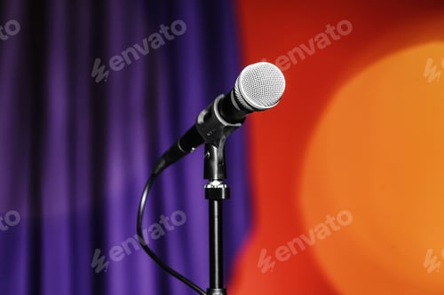 Preview: Stand with microphone on color background. Blurred lights
