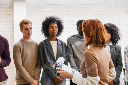 Preview: Female manager leading a meeting with her team in coworking space