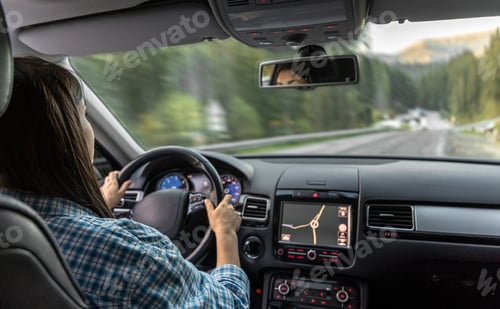 Preview: Woman driving a car, hands on the wheel close-up, view from the back to the road.