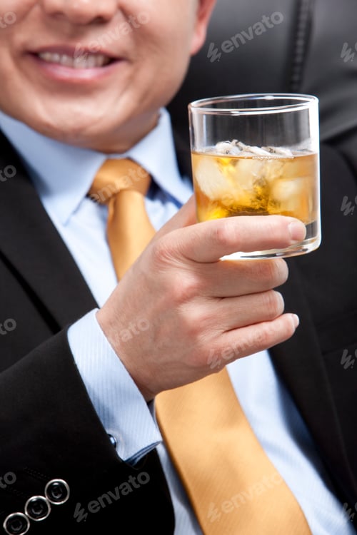 Preview: Businessman holding a glass of whiskey