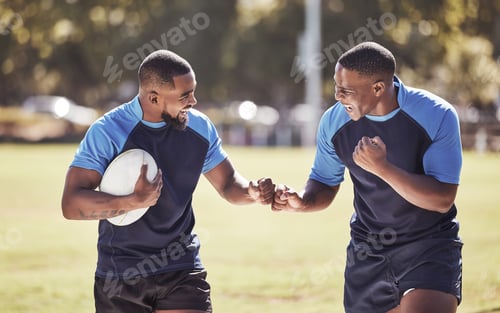 Preview: Two african american rugby teammates celebrating scoring a try or winning a match outside on a spor