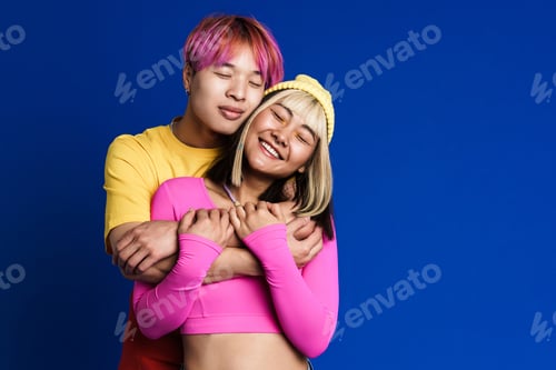 Preview: Asian couple with multicolored hair hugging while smiling together