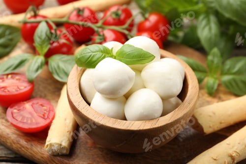 Preview: Tasty mozzarella cheese balls, tomatoes, basil and grissini on table, closeup
