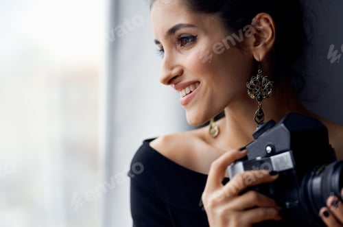 Preview: pretty woman in a black dress near the window posing fashion model