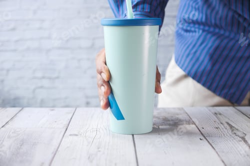 Preview: Hand holding stylish reusable eco coffee cup.