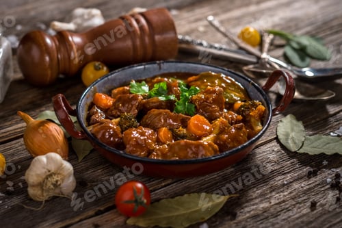 Preview: Meat stew with vegetable on rustic wooden background