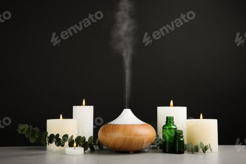Preview: Composition with essential oils diffuser on table against black background. Space for text