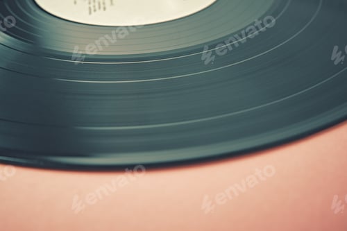 Preview: Old retro vinyl disc on a pink background. Vintage toned photo