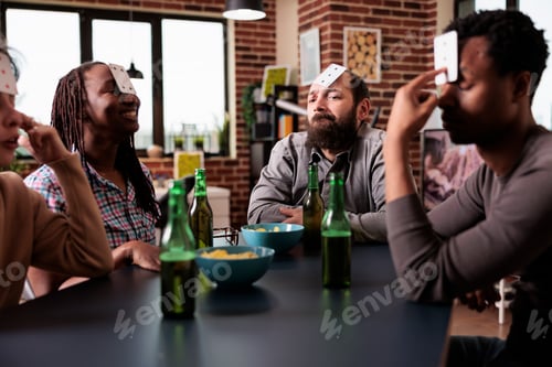 Preview: Diverse group of friends playing guessing card game together while sitting at home.
