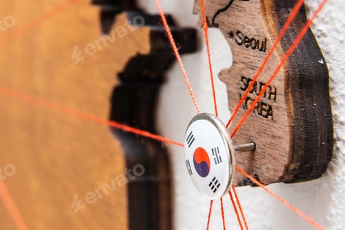 Preview: South Korea flag on the pin with red thread showed the paths on the wooden map.