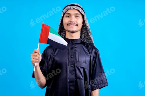 Preview: Young Asian Man Wearing Arabic Style Smiling While Holding Flag Of United Arab Emirates