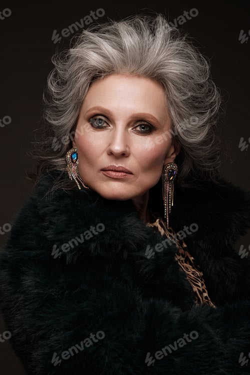 Preview: Portrait of elderly woman in a leopard blouse and fur coat with classic makeup and gray hair.