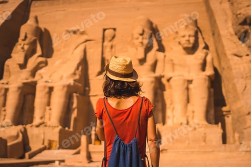 Preview: A Young Tourist In A Red Dress And Straw Hat Walking Towards The Abu Simbel Temple In Southern