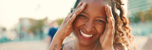 Preview: Closeup portrait of smiling woman with long curly hair on urban city background