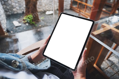 Preview: Mockup image of a woman holding digital tablet with blank white desktop screen in cafe