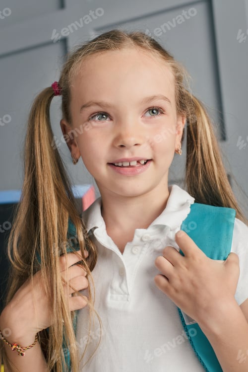 Preview: Happy schoolchild in the classroom with big backpack