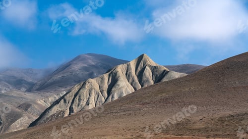 Preview: Mountain peaks with clouds on a blue sky