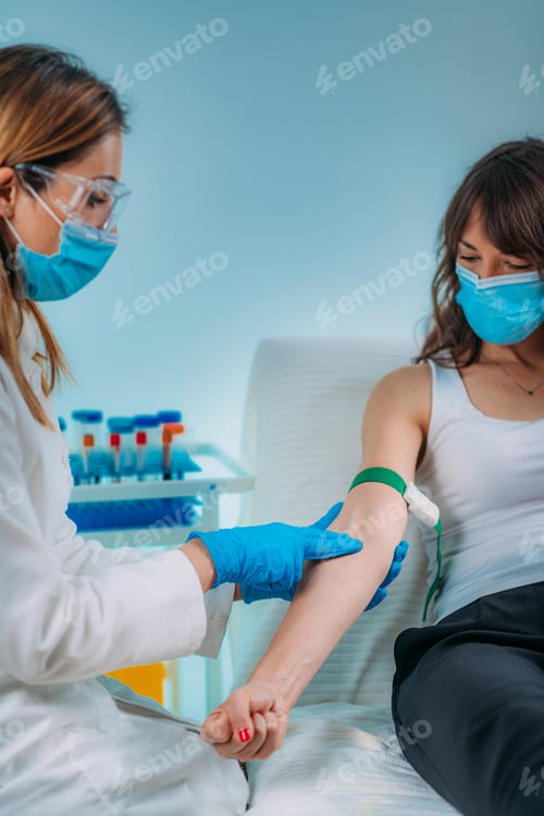 Preview: Preparation for phlebotomy procedure, female patient and medical nurse wearing protective masks