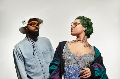 Preview: Chic multicultural couple poses in stylish outfits and sunglasses for a photoshoot