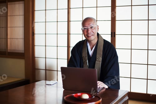 Preview: Buddhist monk using a computer laptop and smart phone