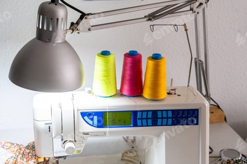 Preview: Sewing machine with colorful threads creating new fashion