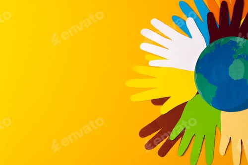 Preview: Paper cut out of multi coloured hands and globe with copy space on yellow background