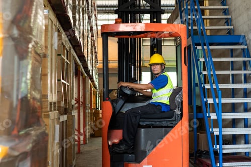 Preview: Asian senior man driving forklift truck in the warehouse distribution