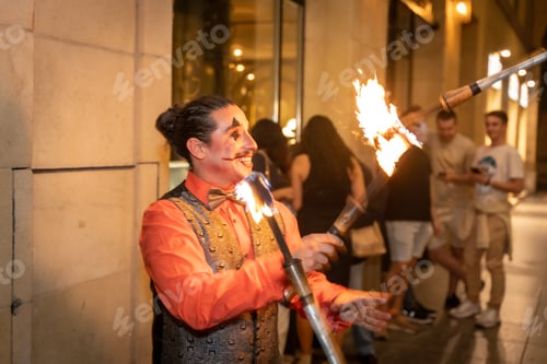 Preview: Juggler at a halloween party juggling sticks with fire, at the entrance to the nightclub