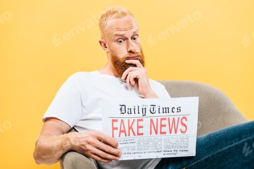 Preview: thoughtful man reading newspaper with fake news while sitting on armchair, isolated on yellow