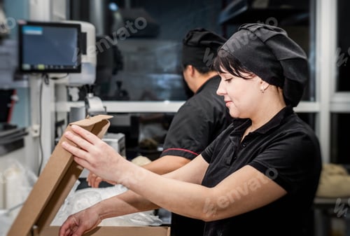 Preview: Women cooks in black uniforms working at the kitchen of the restaurant