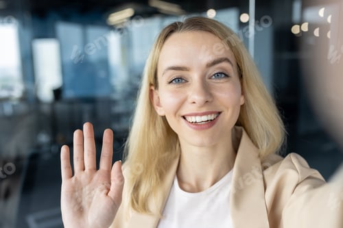 Preview: Professional woman smiling and waving in a modern office
