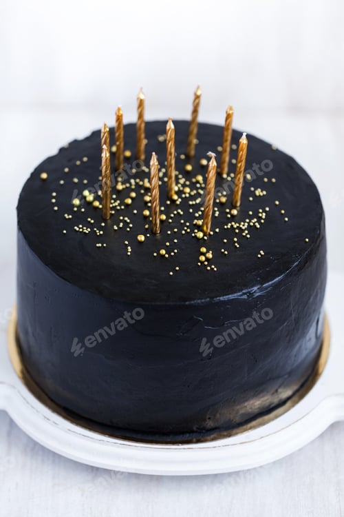 Visualização: Bolo de aniversário preto com velas douradas sobre fundo branco