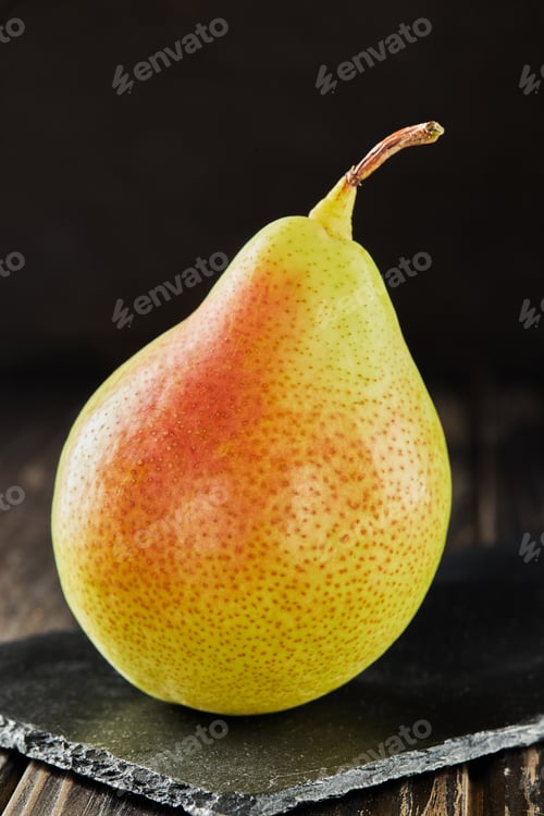 Preview: Fresh pear on black stone on wooden background