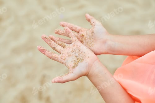 Preview: Child Shows Hands Covered With Sand While Playing at the Beach