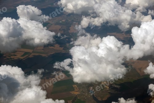 Preview: Aerial view from airplane window of white puffy clouds on bright sunny day.