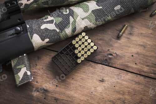 Preview: Small caliber 22 long rifle with an optical sight and cartridges in camouflage tape