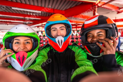 Preview: Friends taking selfie at karting track smiling