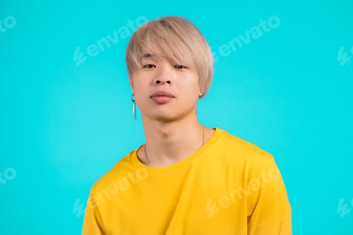 Preview: Portrait of stylish korean man looking to camera. Asian guy with dyed blonde hairstyle in studio