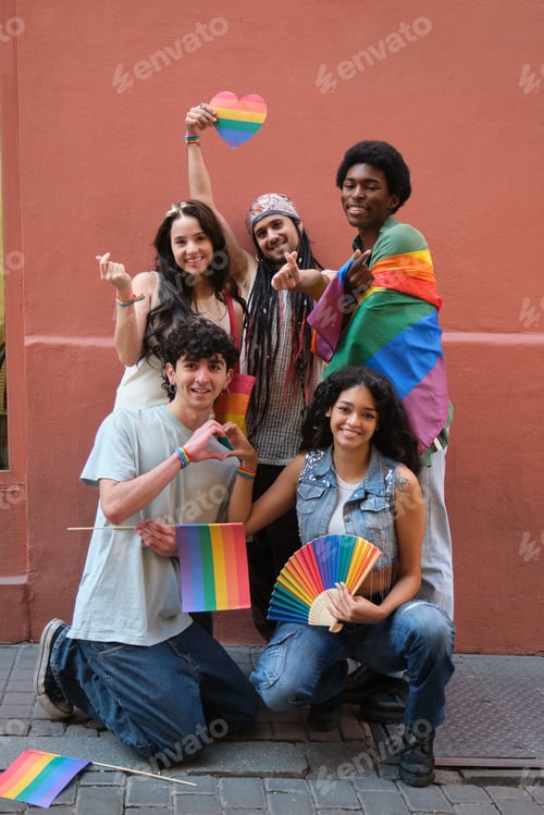 Preview: Young activists showing rainbow flags and heart shape celebrating gay pride