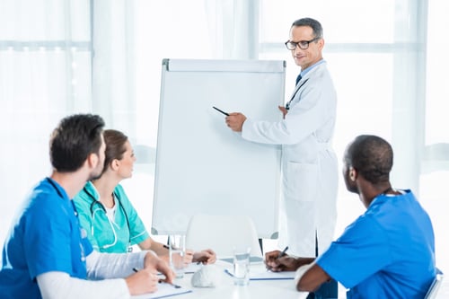 Preview: handsome mature general practitioner making presentation for colleagues