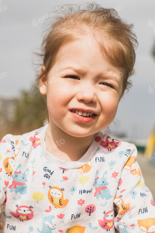 Preview: Portrait of smile little girl squinted from the sun