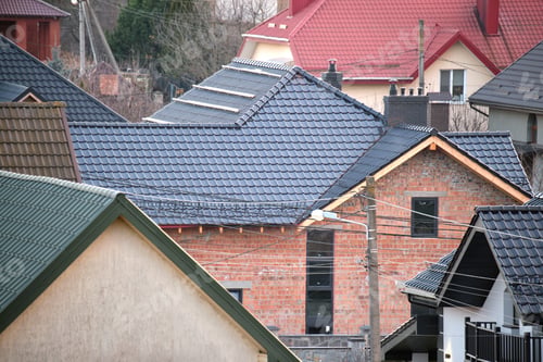 Preview: Residential houses with roof tops covered with metallic and ceramic shingles in rural suburban area