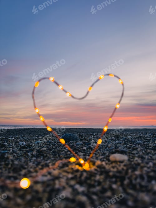 Preview: heart symbol with bright fairy lights on the beach